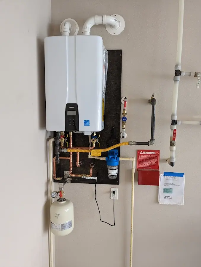 Professional plumber installing copper piping in a Bloomer home